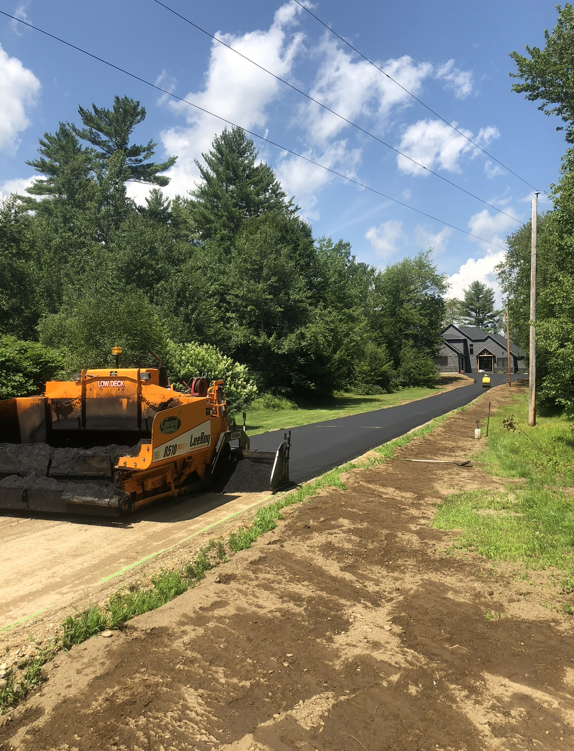 Residential driveway paving in progress, using professional asphalt equipment for a clean, long-lasting finish.