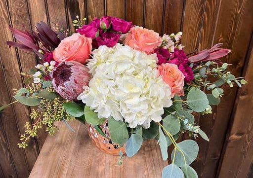 This Sweet arrangement will brighten any room. It's small size has great impact with beautiful colors of hydrangeas, kahala roses, spray roses and stock with assorted greenery.