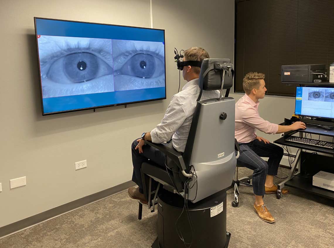 Cory Tickle (audiologist) and Matt Wilken (audiologist) illustrate what a hearing test looks like in the Colorado Ear Care Offices