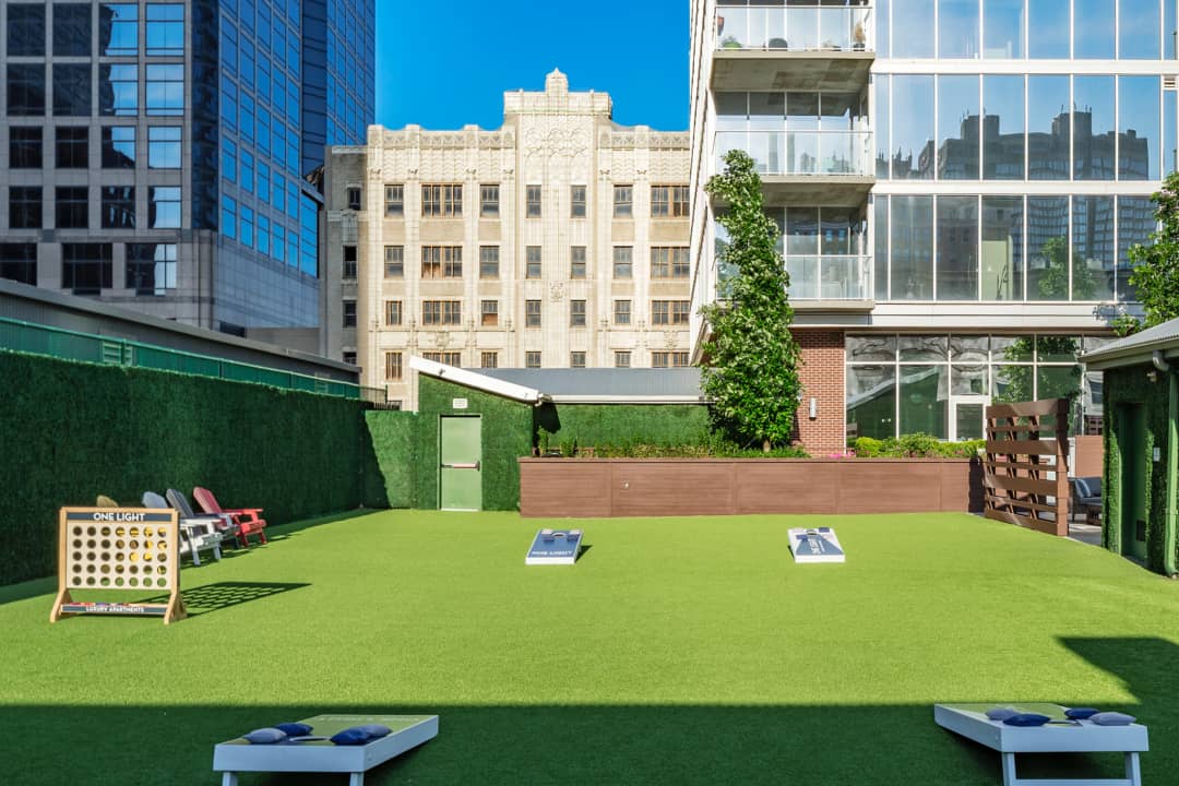 Rooftop Green Space Residents can play a game of cornhole, connect four, bocce ball or just toss a football on the rooftop of One Light within the artificial turf area.