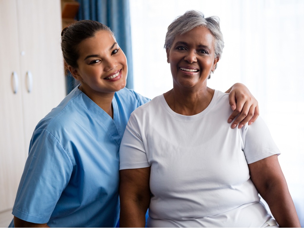 caregiver providing friendly, supportive care to a senior woman in a comfortable home setting, highlighting quality in-home assistance and companionship.