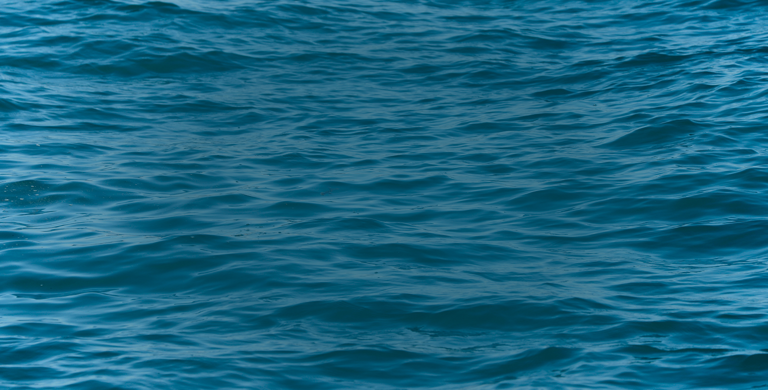 A textured surface of rippling blue ocean water.