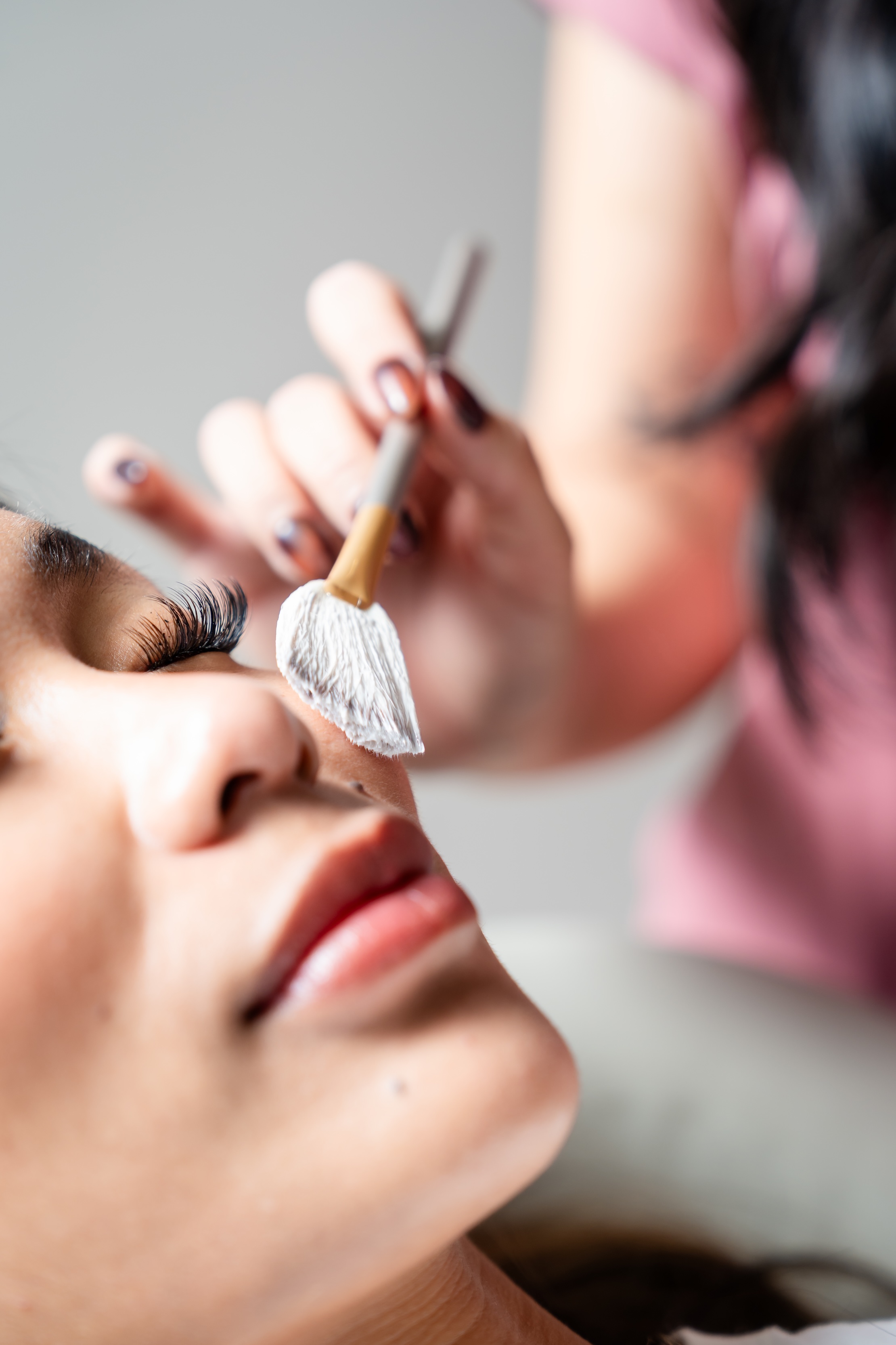esthetician applying a facial treatment on a client