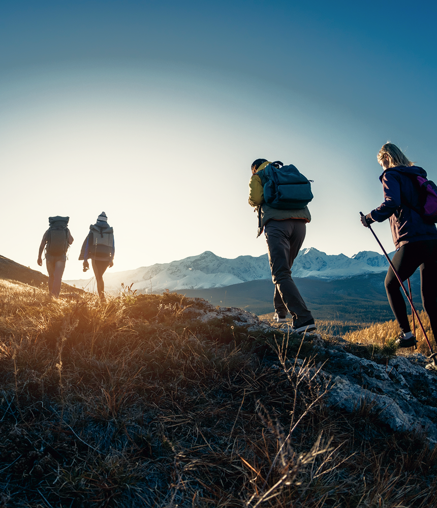 A group on a scenic hike with mountains in the background.