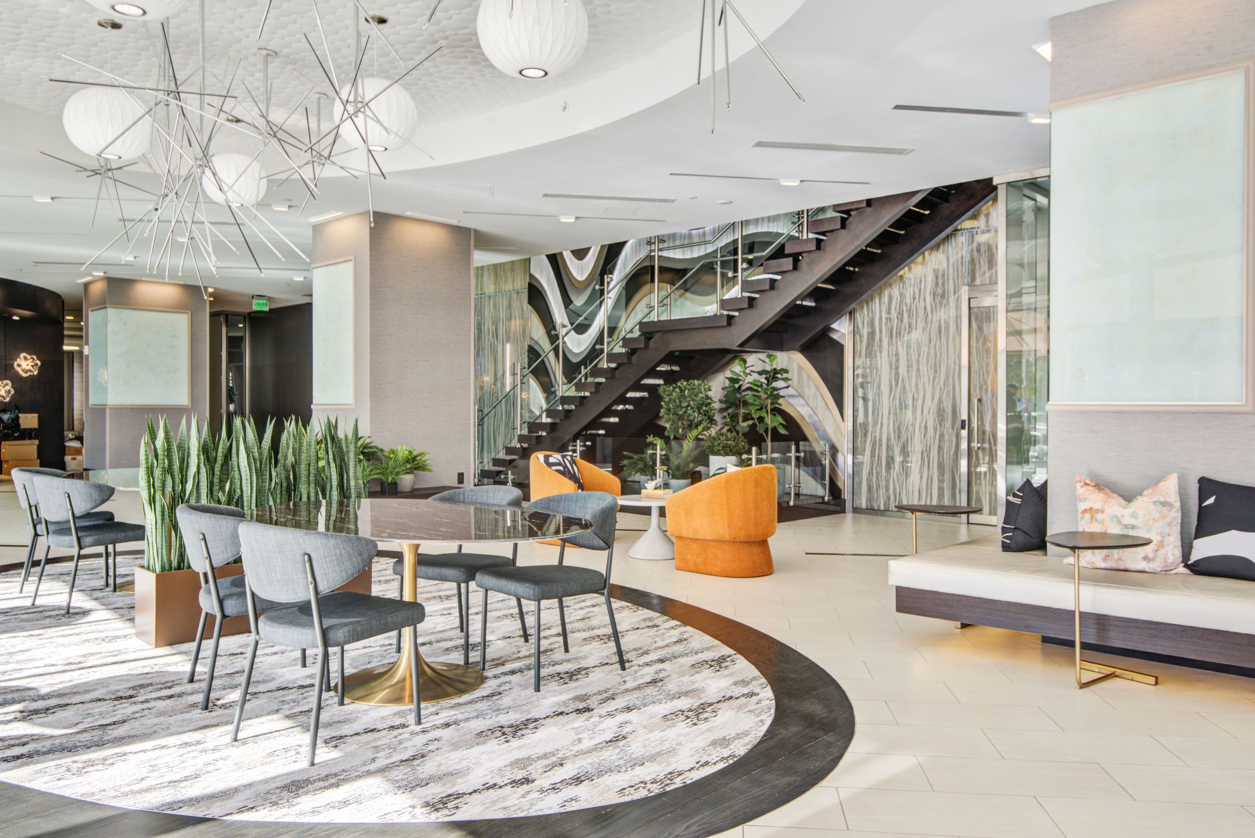 Lobby with lounging areas, grand staircase and mixed media art wall