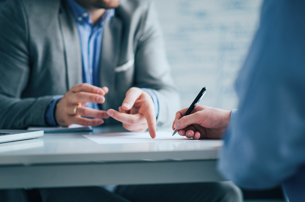 Close-up of wealth professionals collaborating on a document.
