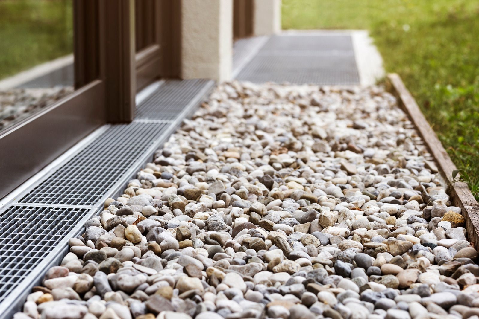 Gravel drainage system installed along a residential building foundation to improve water runoff and prevent moisture damage. Proper grading and stone placement enhance durability, protect structures, and support effective drainage solutions for long-term property maintenance and stability.