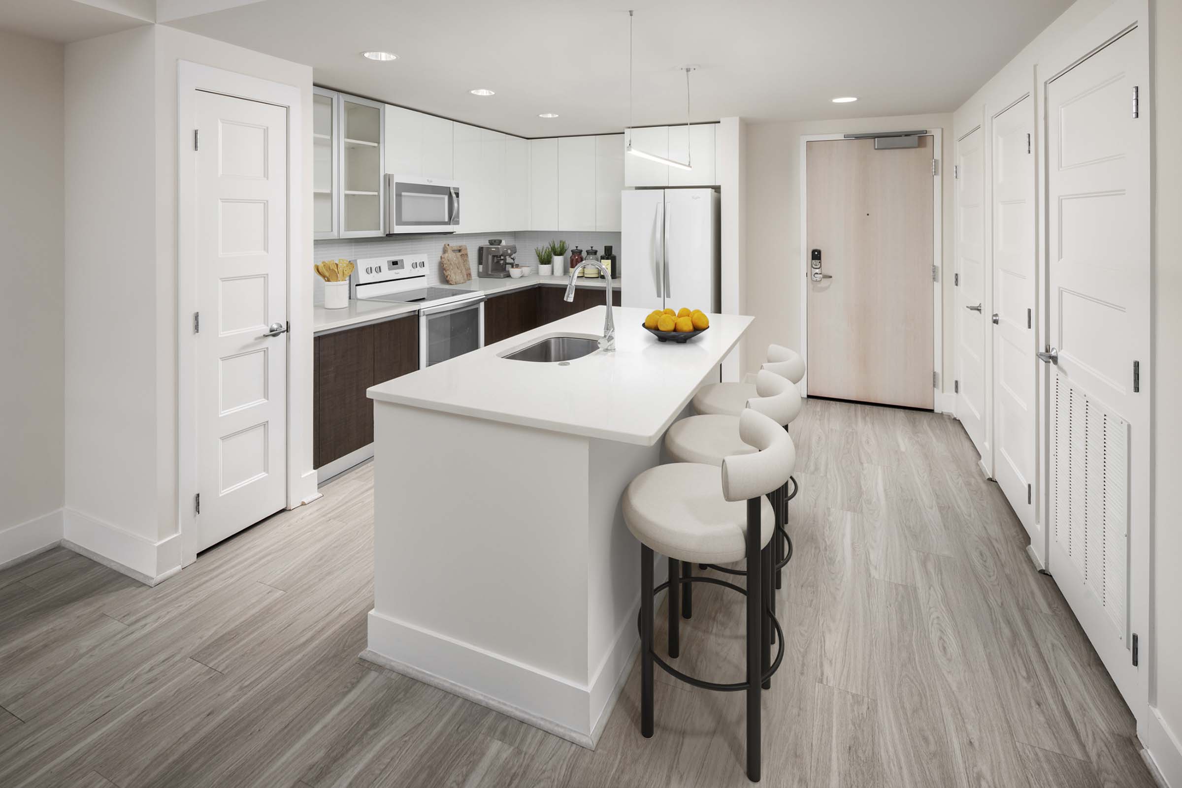 Contemporary style kitchen with white appliances and an island at Camden NoMa Apartments in Washington, DC.