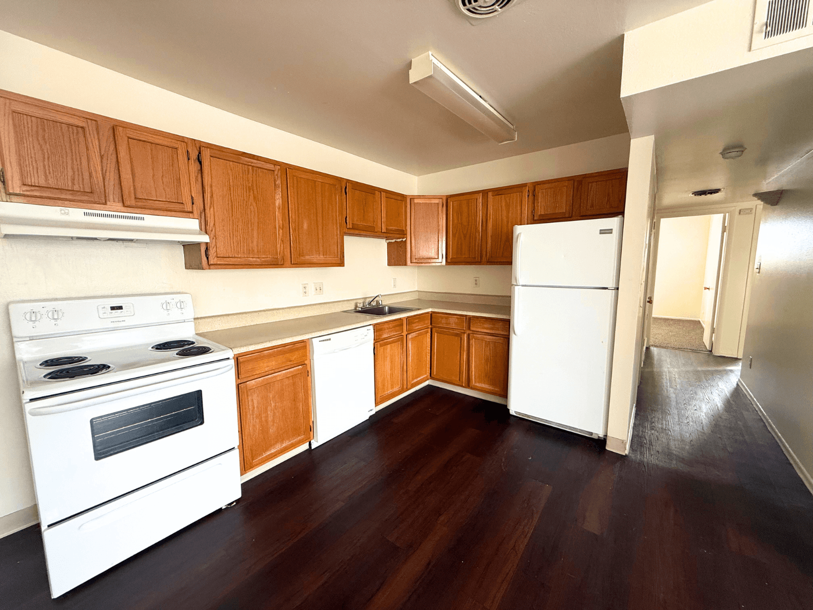 A kitchen with white appliances and wooden cabinets