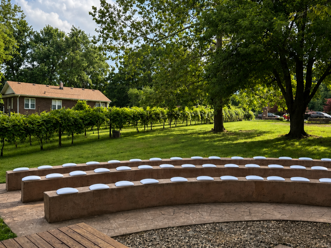 Amphitheater with the vineyard, trees and green grass and Mulberry house in the background.