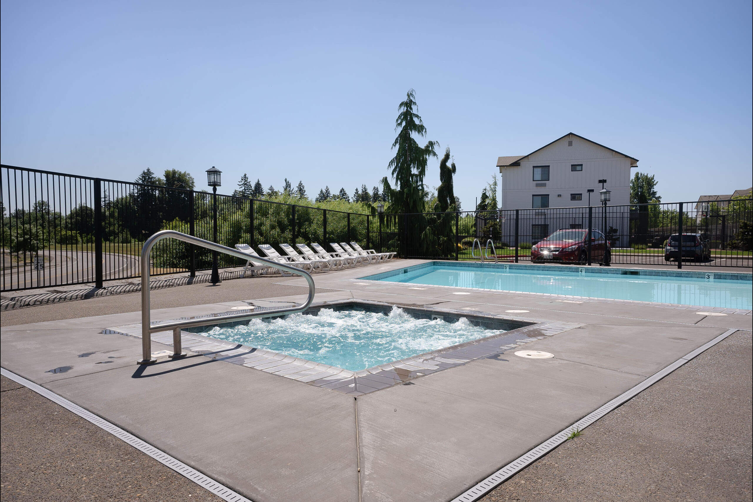 A small pool with a slide and a house in the background.