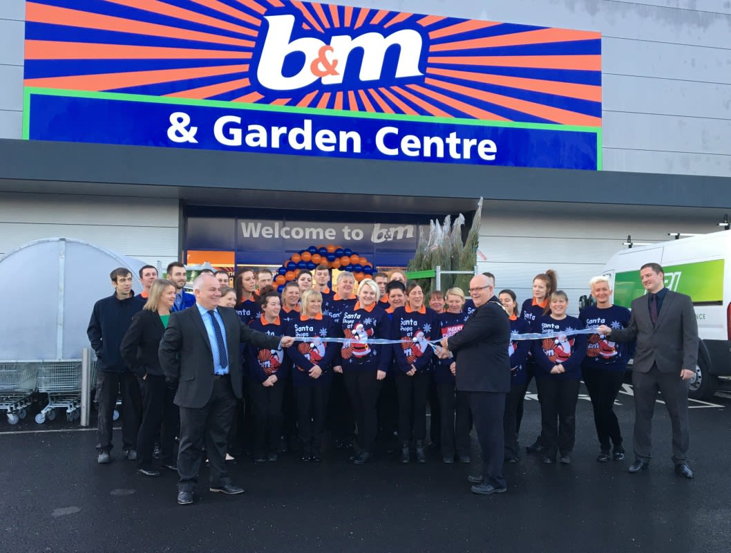 Store staff pose with Mayor of Featherstone, Cllr Steve Vickers as he cuts the ribbon at B&M's new Featherstone store.