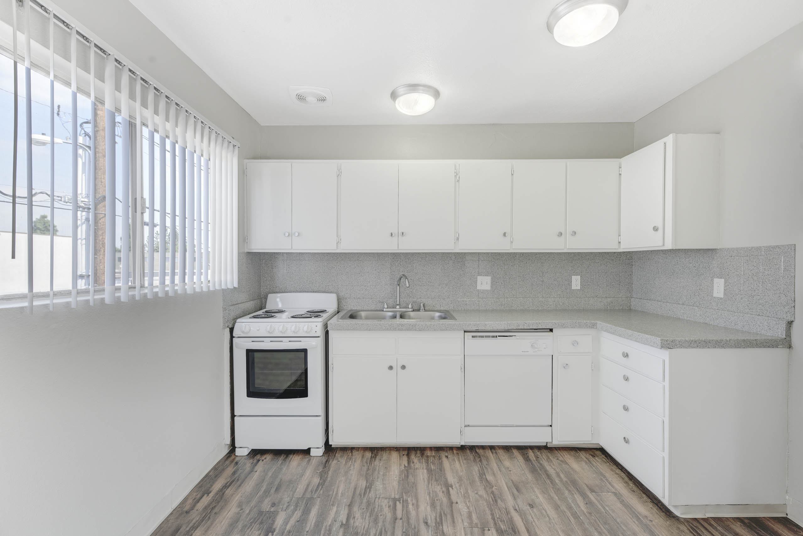 A kitchen with white appliances and cabinets.
