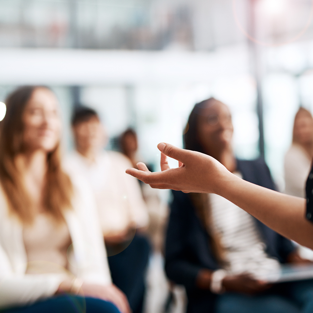 Close-up of a person speaking to a crowd at an event.
