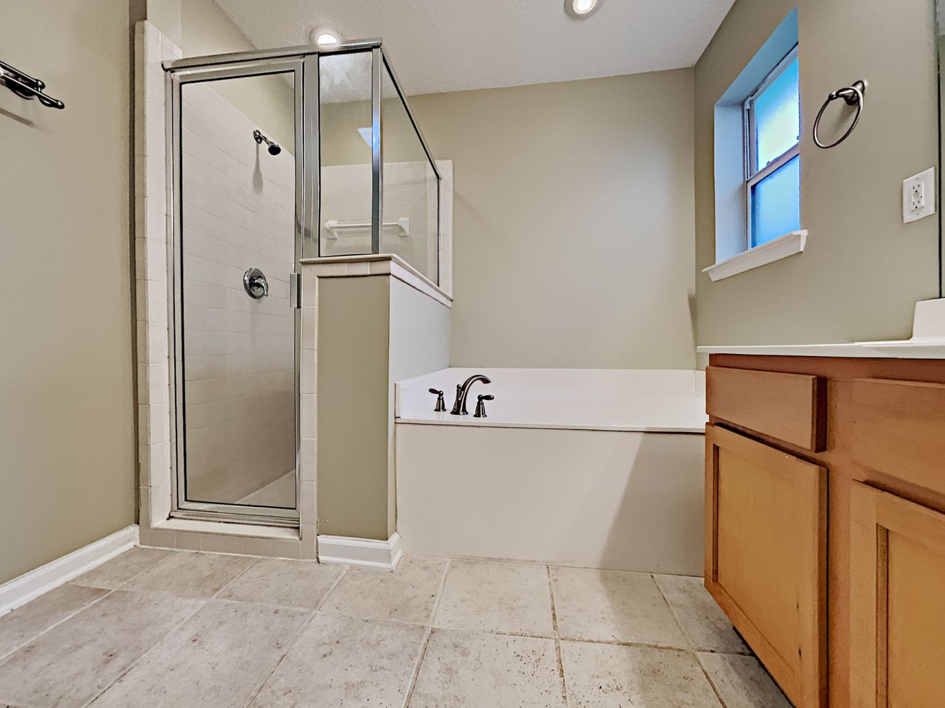 Spacious bathroom with a relaxing tub and separate shower at Invitation Homes Jacksonville.