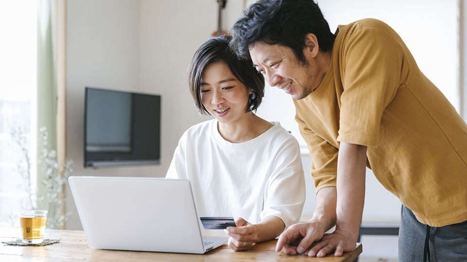 Two people looking at an open laptop computer.