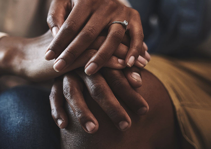 Closeup of a married couple holding hands.