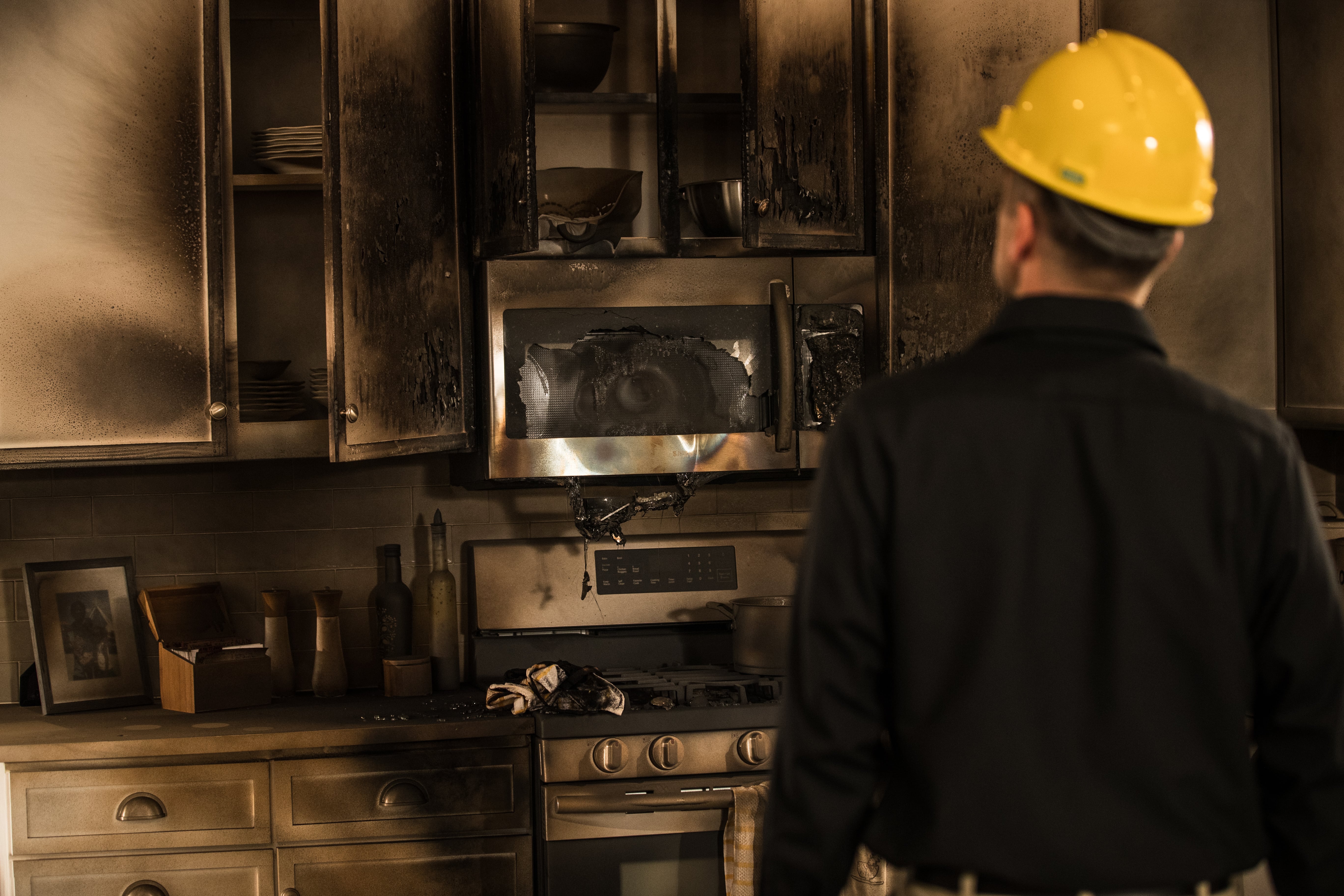 ServiceMaster technician examining a fire-damaged kitchen