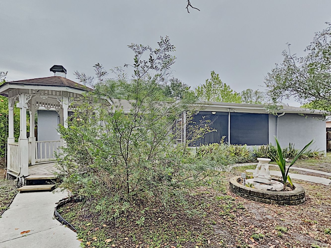 Backyard with gazebo and porch with screen at Invitation Homes Tampa.