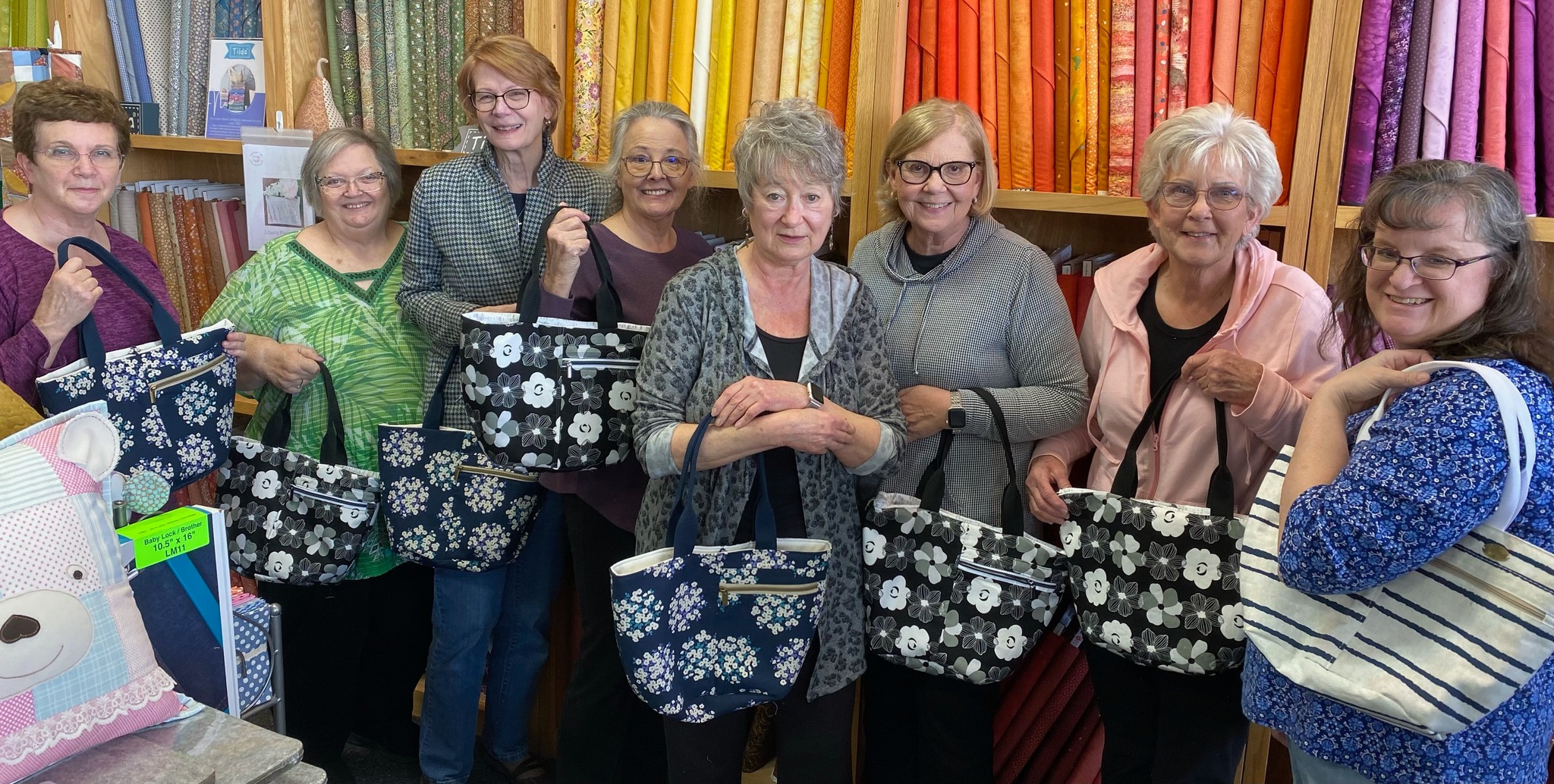 Students proudly display their handmade tote bags after a Decorative Stitch class. This hands-on sewing workshop focused on decorative stitching, bag construction, and creating stylish, functional fabric totes.