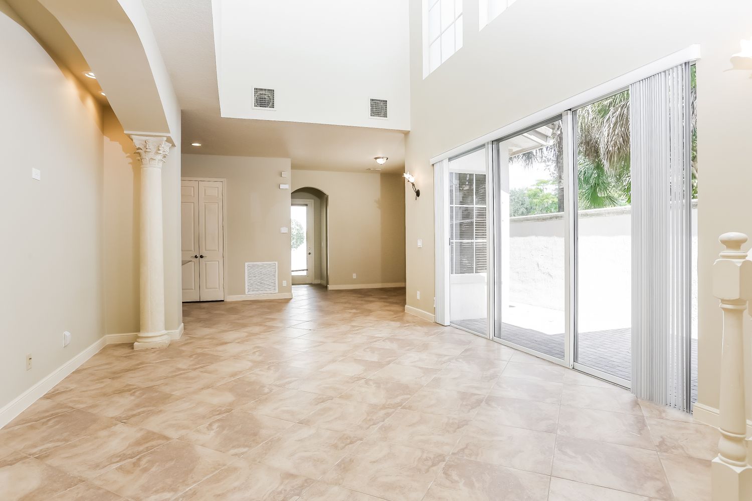 Spacious living area with tile flooring and easy outdoor access at Invitation Homes South Florida.