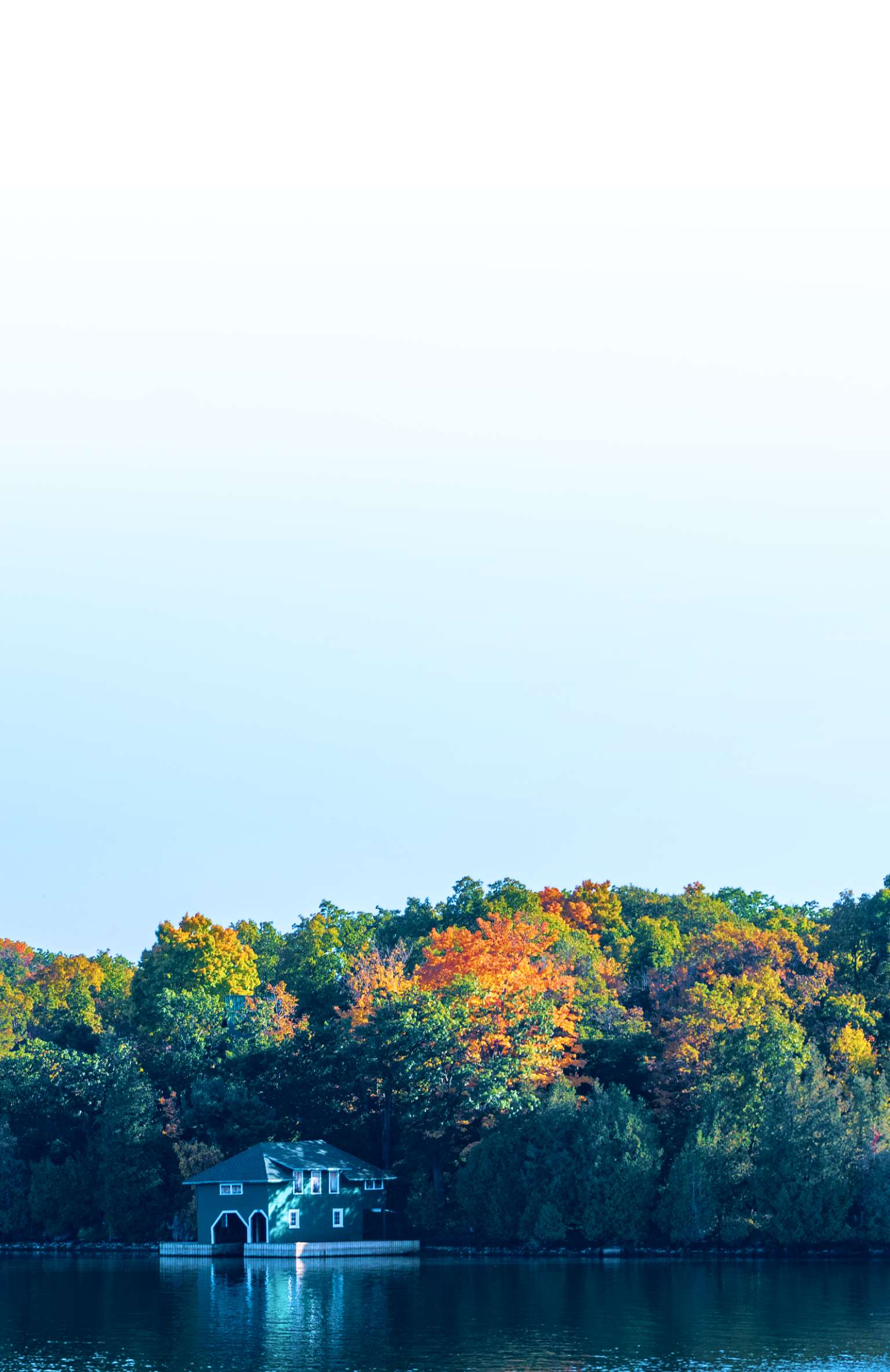 Cottage on a lake with autumn foliage.