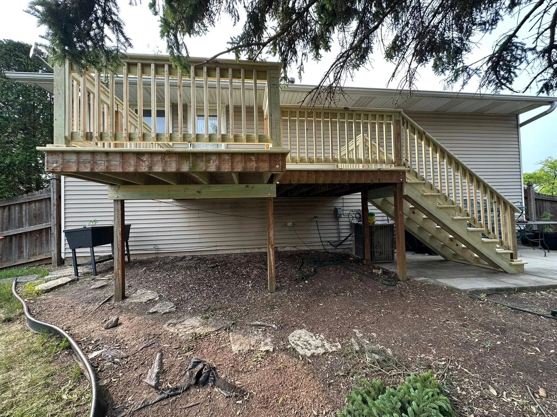 Freshly rebuilt pressure-treated wooden deck features upgraded railings, sturdy framing, spacious platform, secure stairs, professional craftsmanship, and durable outdoor construction designed for long-lasting residential performance and safety.