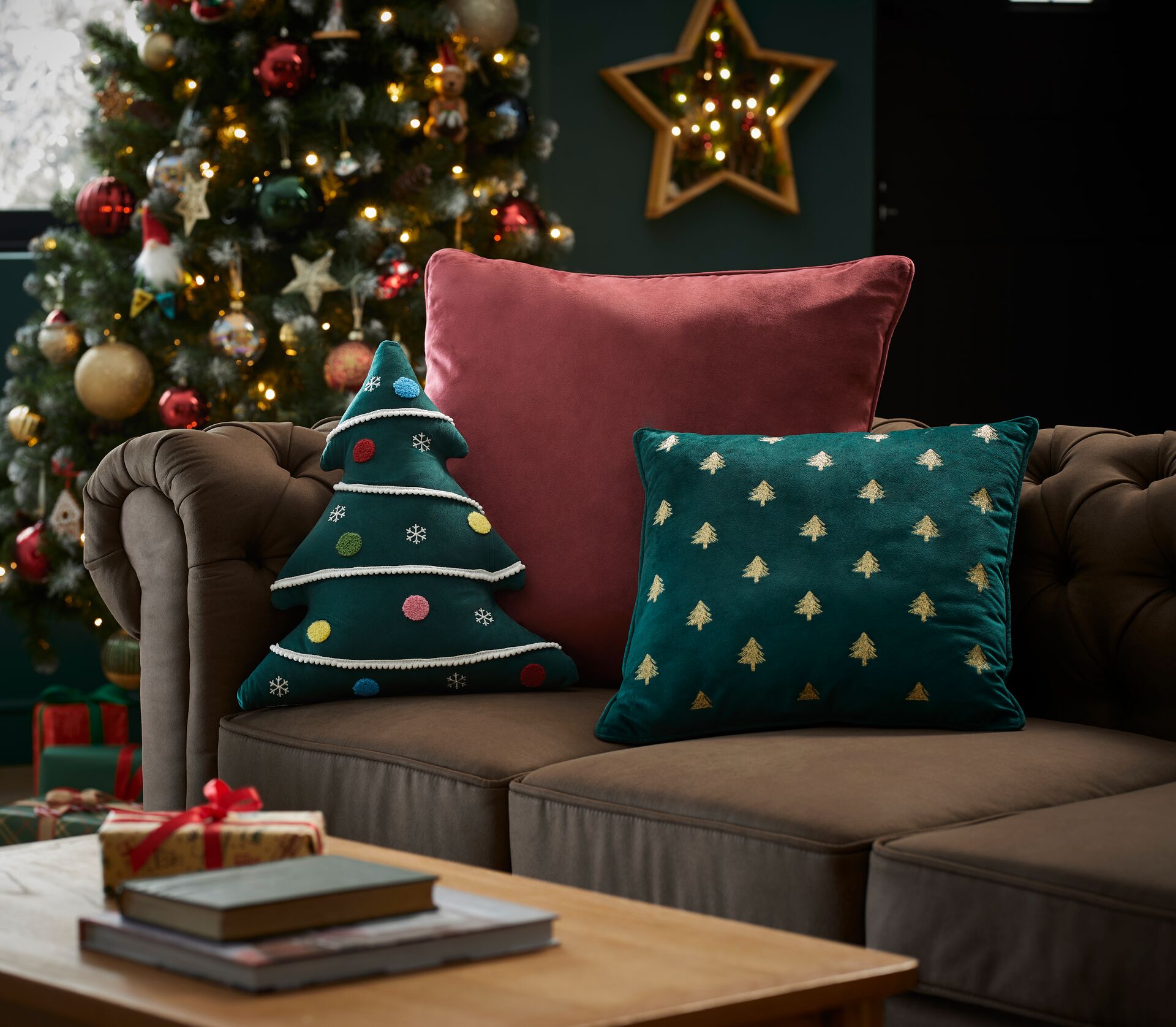 A couch decorated with different styles and colours of Christmas cushions