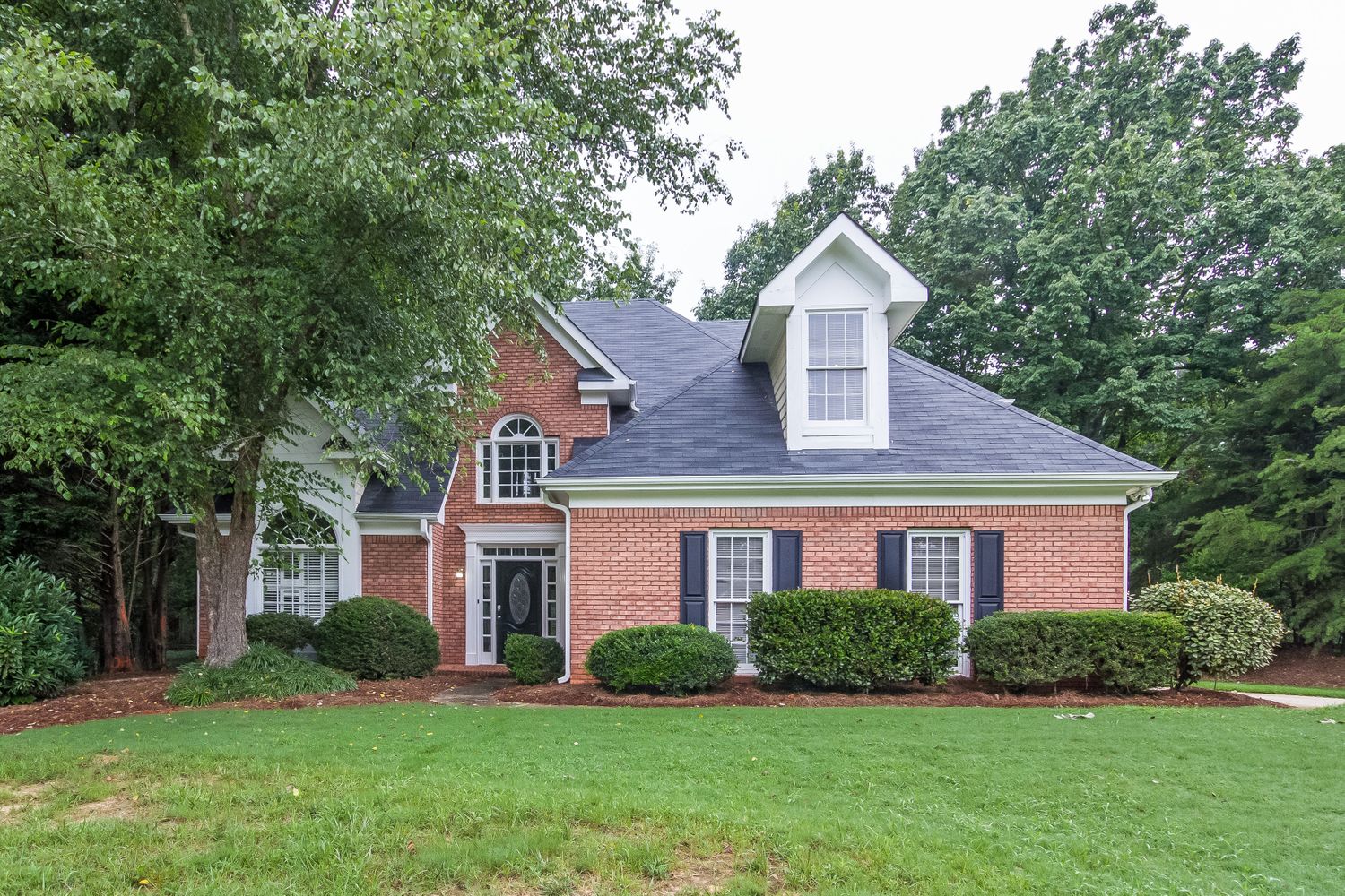 Brick home with beautiful landscaping at Invitation Homes Atlanta.