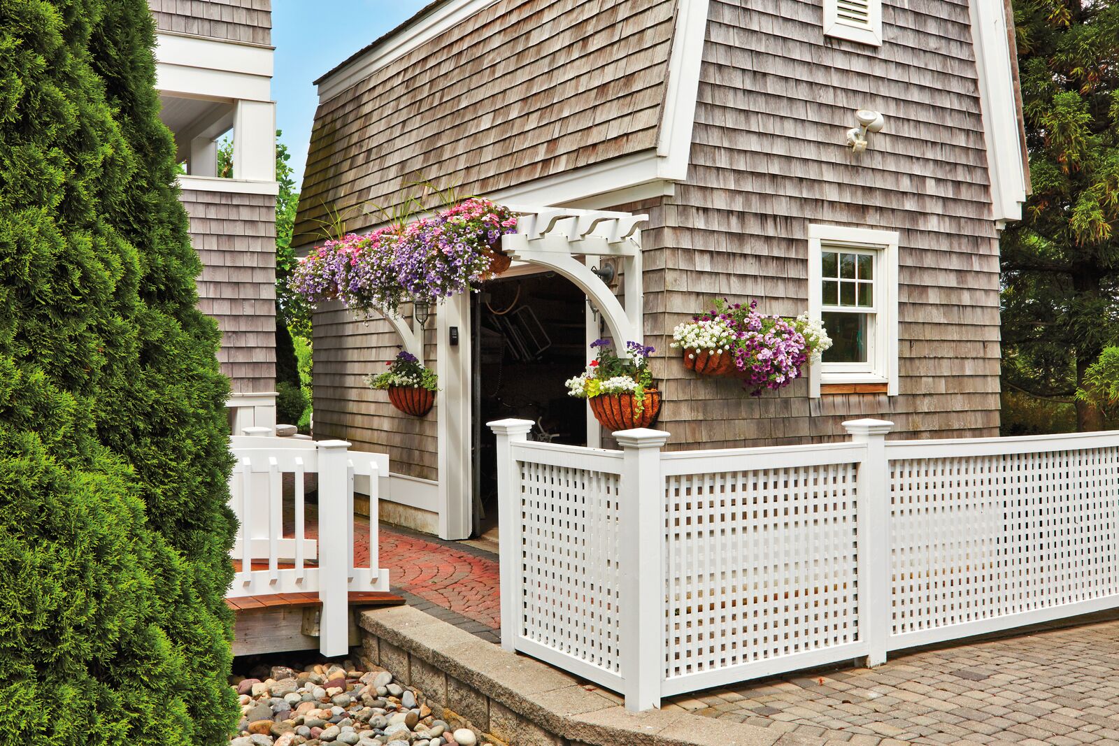 From curbside to backyard, Walpole Outdoors has the fencing, pergolas, automatic driveway gates, arbors and other outdoor structures - such as cabanas, gazebos, and pavilions - to transform the area around your home into all that you would ever want it to be. At our Norwalk, CT store, you'll see exceptional styles in handcrafted fences. Walpole has more than 40 standard fence styles to choose from, including picket fencing, lattice fencing, privacy board fencing, and - working from your drawings, specifications, or photographs - we'll custom craft fencing to complement your specific needs and your home's architecture. Walpole Outdoors pergolas are the standard all others are measured by, for style and handcrafted excellence in construction. You may be considering an attached pergola for your patio, porch, or entranceway, or a freestanding pergola for an area by the pool or in your yard. Whatever your requirements, your Walpole pergola can be the outdoor room of your dreams - with an outdoor kitchen, furniture, and a manual or automatic Walpole pergola canopy on top.