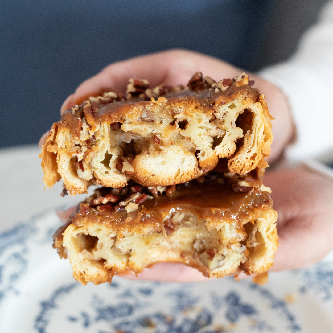 A close-up of maman's freshly baked pecan sticky bun reveals buttery laminated pastry, caramel glaze 