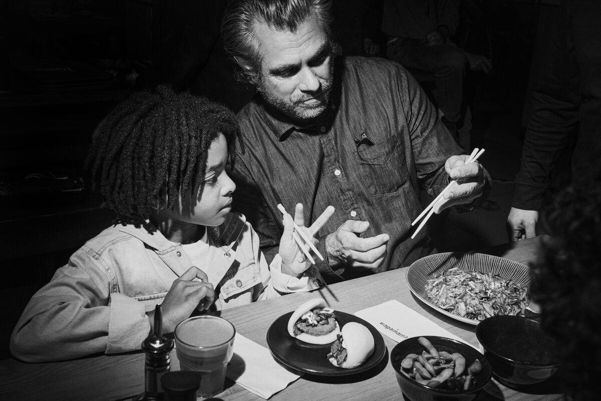 man and child eating with chopsticks at wagamama