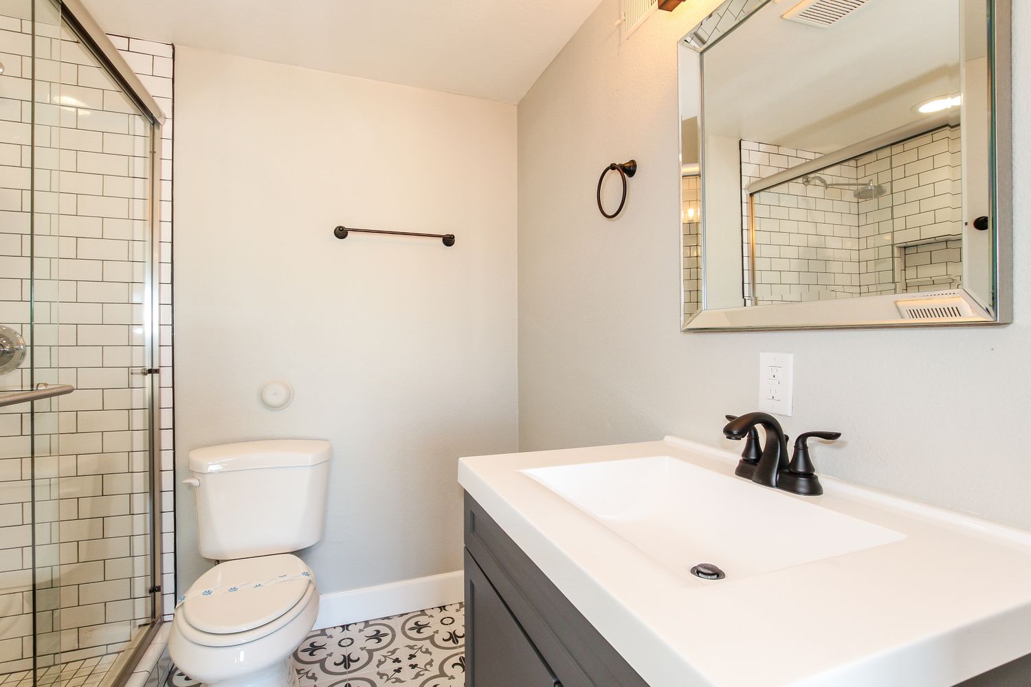 Upgraded bathroom with sleek tile and a spacious shower at Invitation Homes Phoenix.