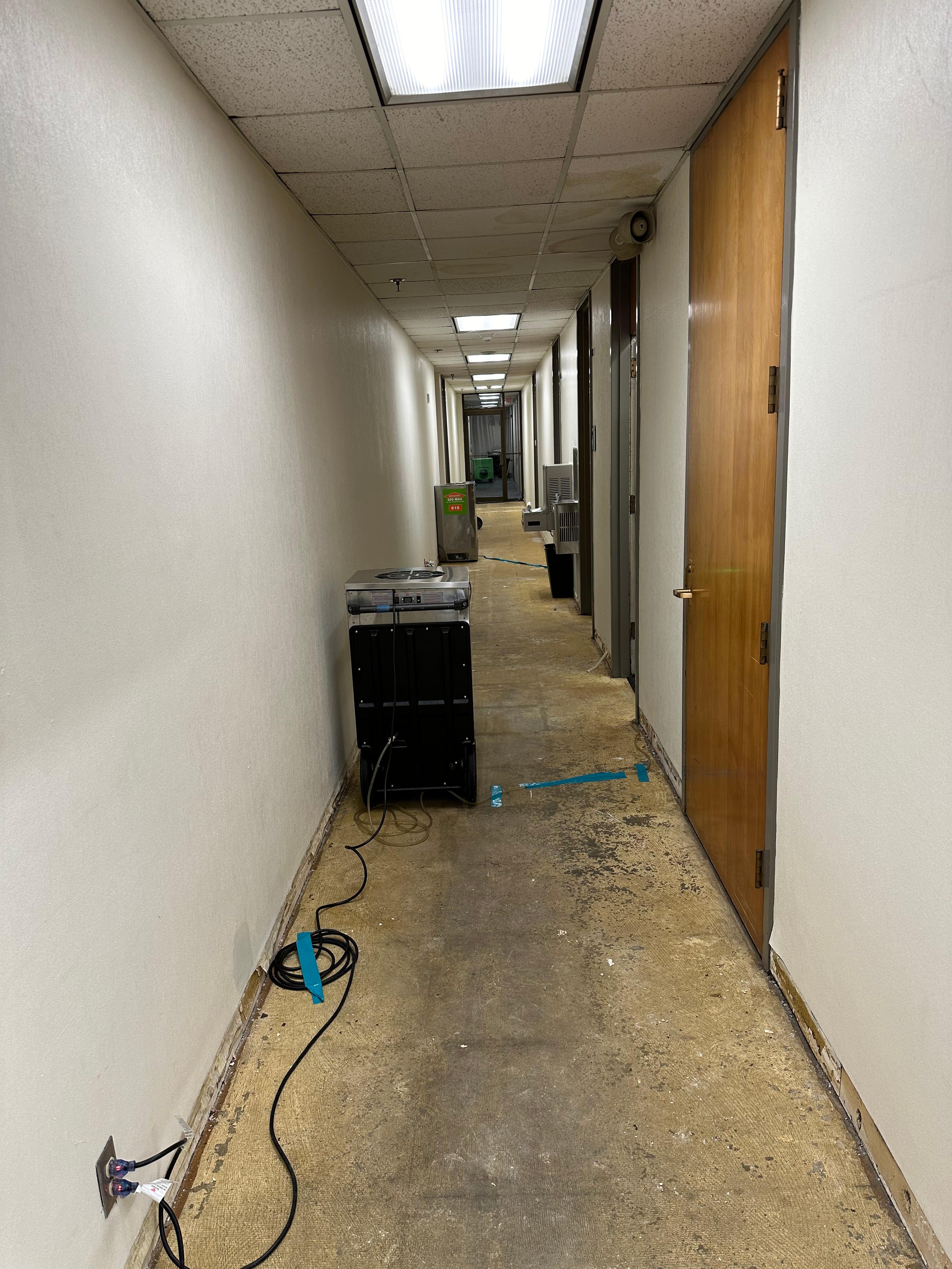 SERVPRO air dryers deployed down the hallway after flooring has been removed.