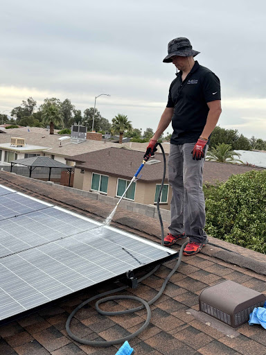 Professional rooftop solar panel cleaning at a residential property, demonstrating hands-on maintenance of a home photovoltaic system.