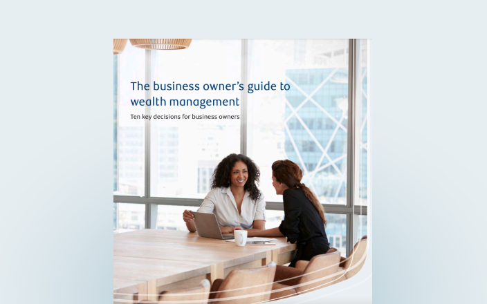 Cover of the business owner's guide featuring two professionals at a board room table.