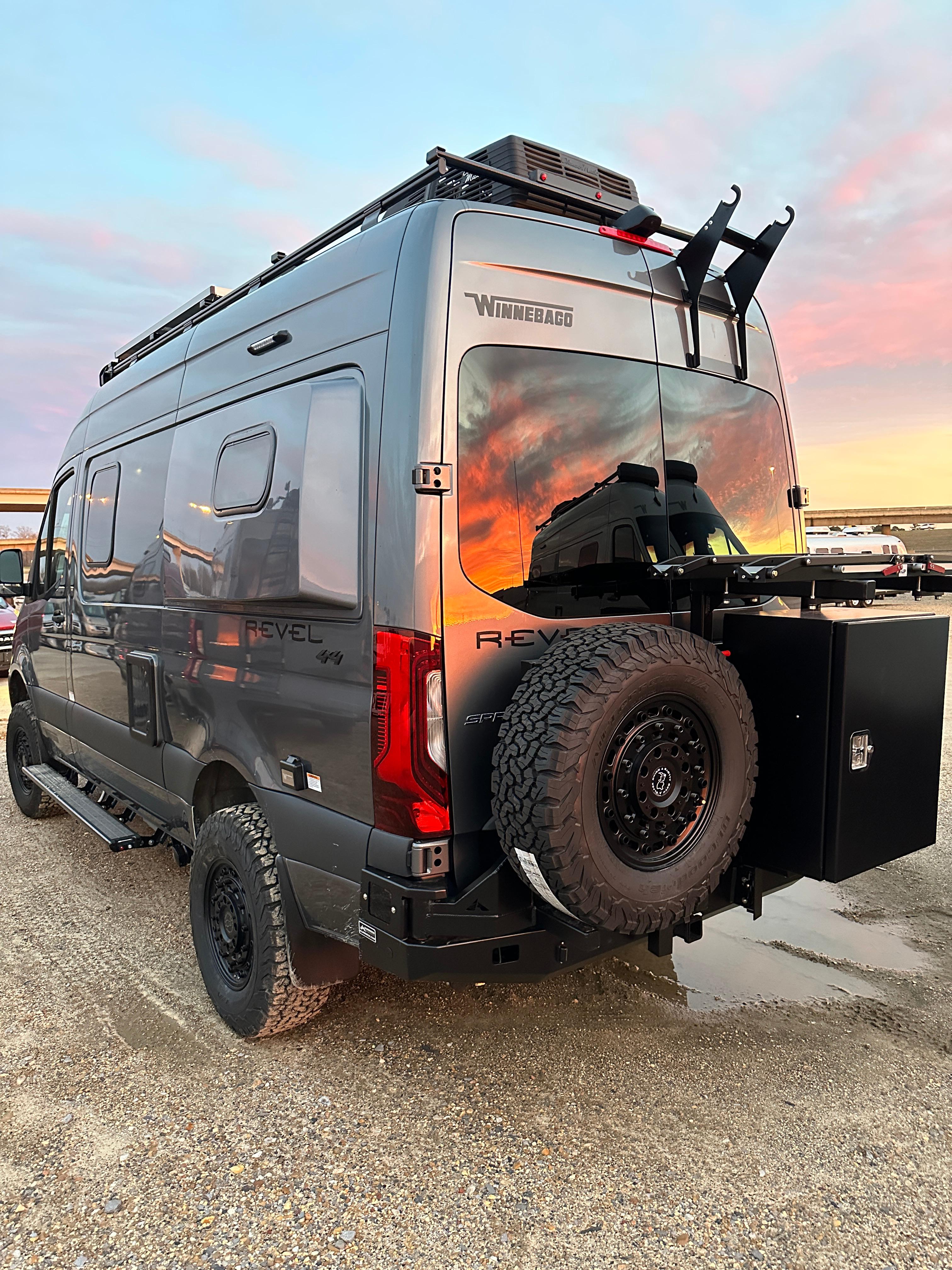 Upfitted Winnebago Revel on 144 Sprinter 4x4 Backwoods Adventure Mods Rear accessories with 1-up bike trays and spare tire.