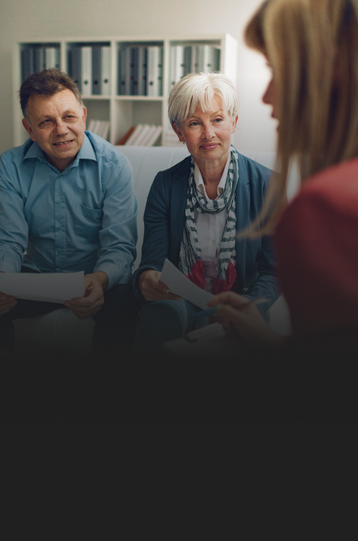 A couple speaking with an advisor in a meeting.
