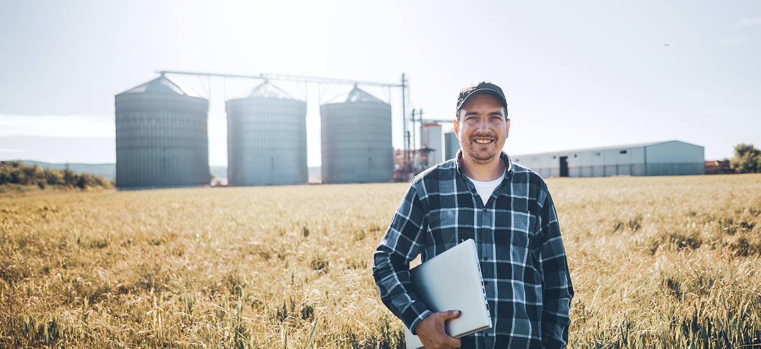 A farmer standing in front of his farm.