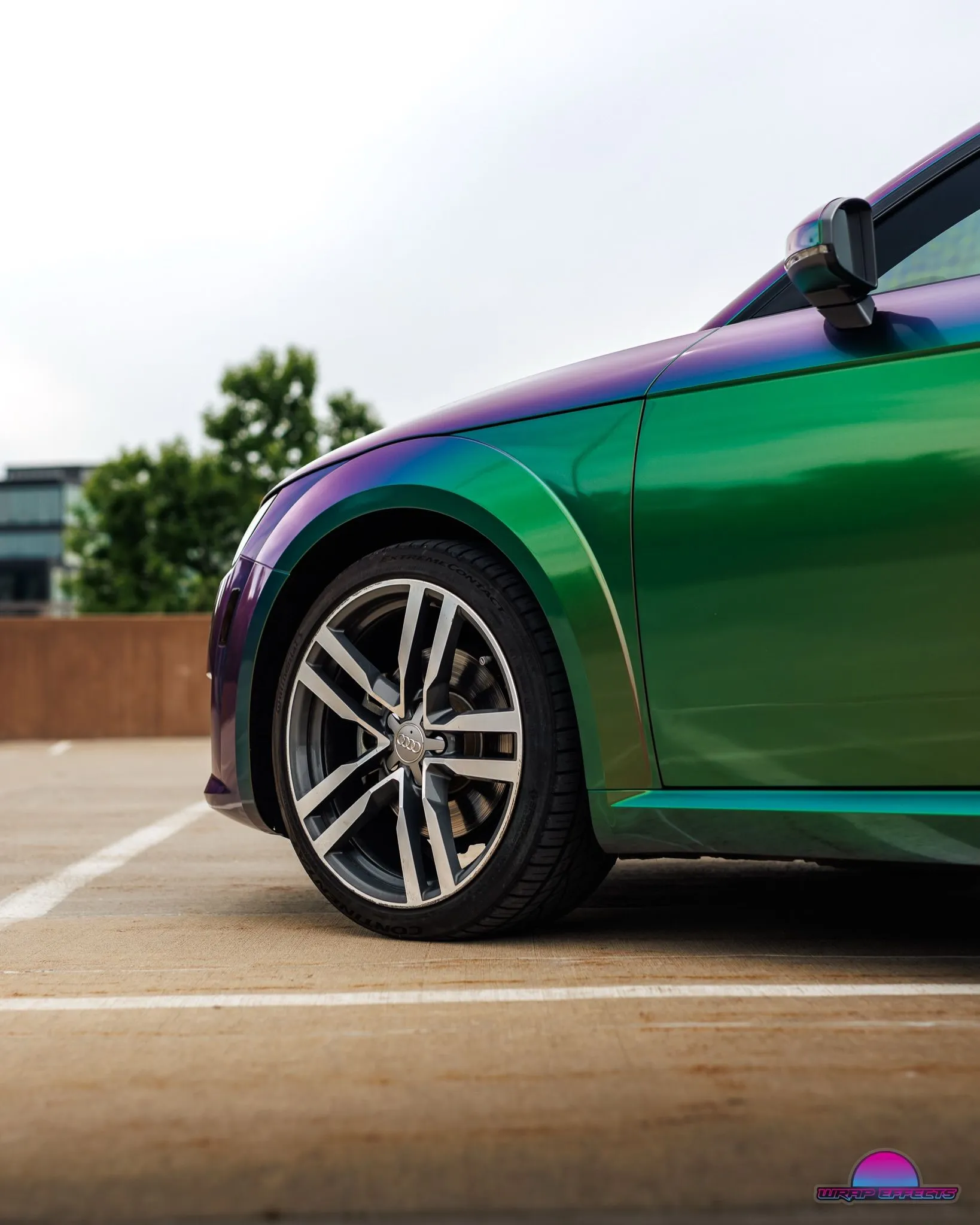 Detailed close-up highlighting Audi TT front wheel, premium alloy rim, color-shifting vinyl wrap, sleek body lines, and flawless automotive finishing emphasizing craftsmanship and precision installation quality.