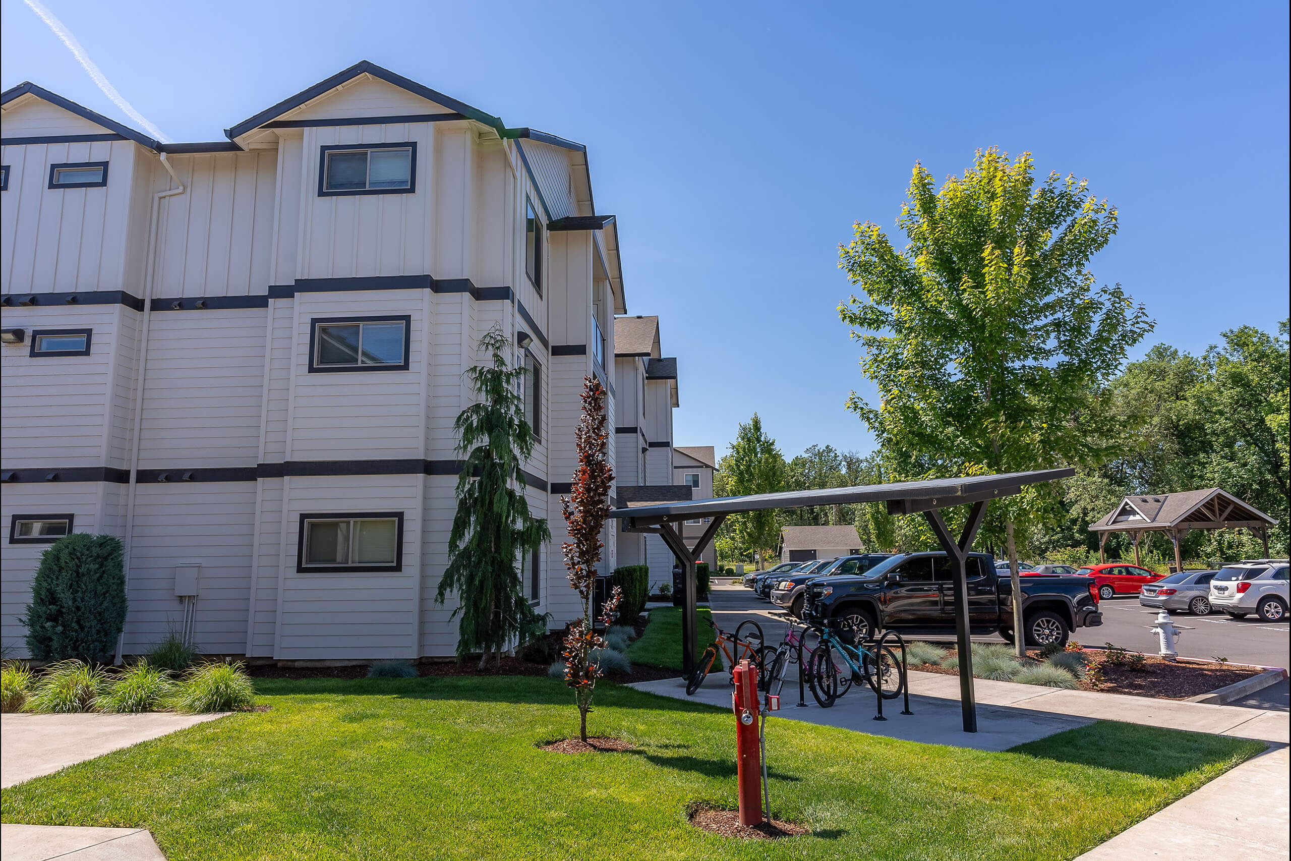 A white apartment building with a green lawn in front.