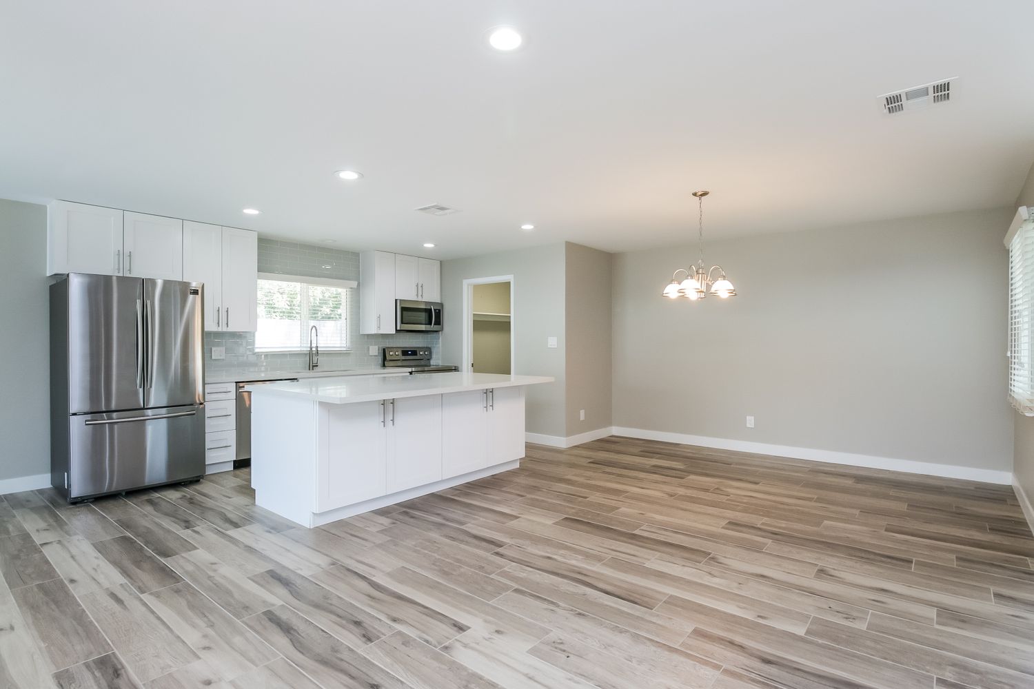 Spacious family room with easy access to the kitchen which has stainless steel appliances at Invitation Homes Phoenix.