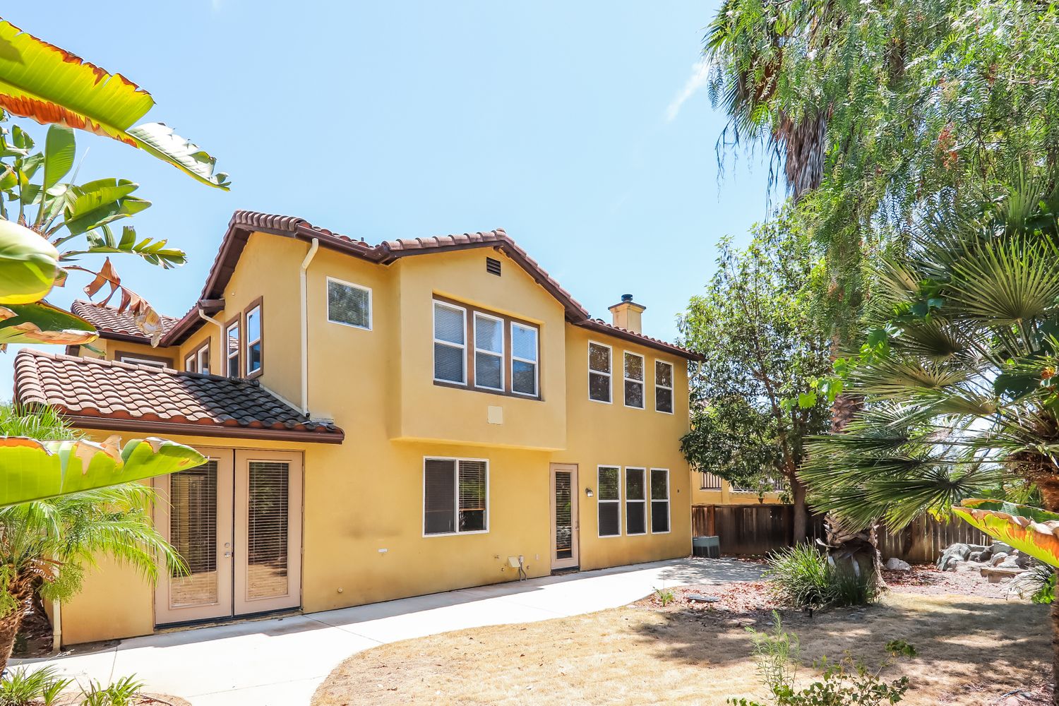 Backyard of home with a lot of windows and double doors at Invitation Homes Pasadena.