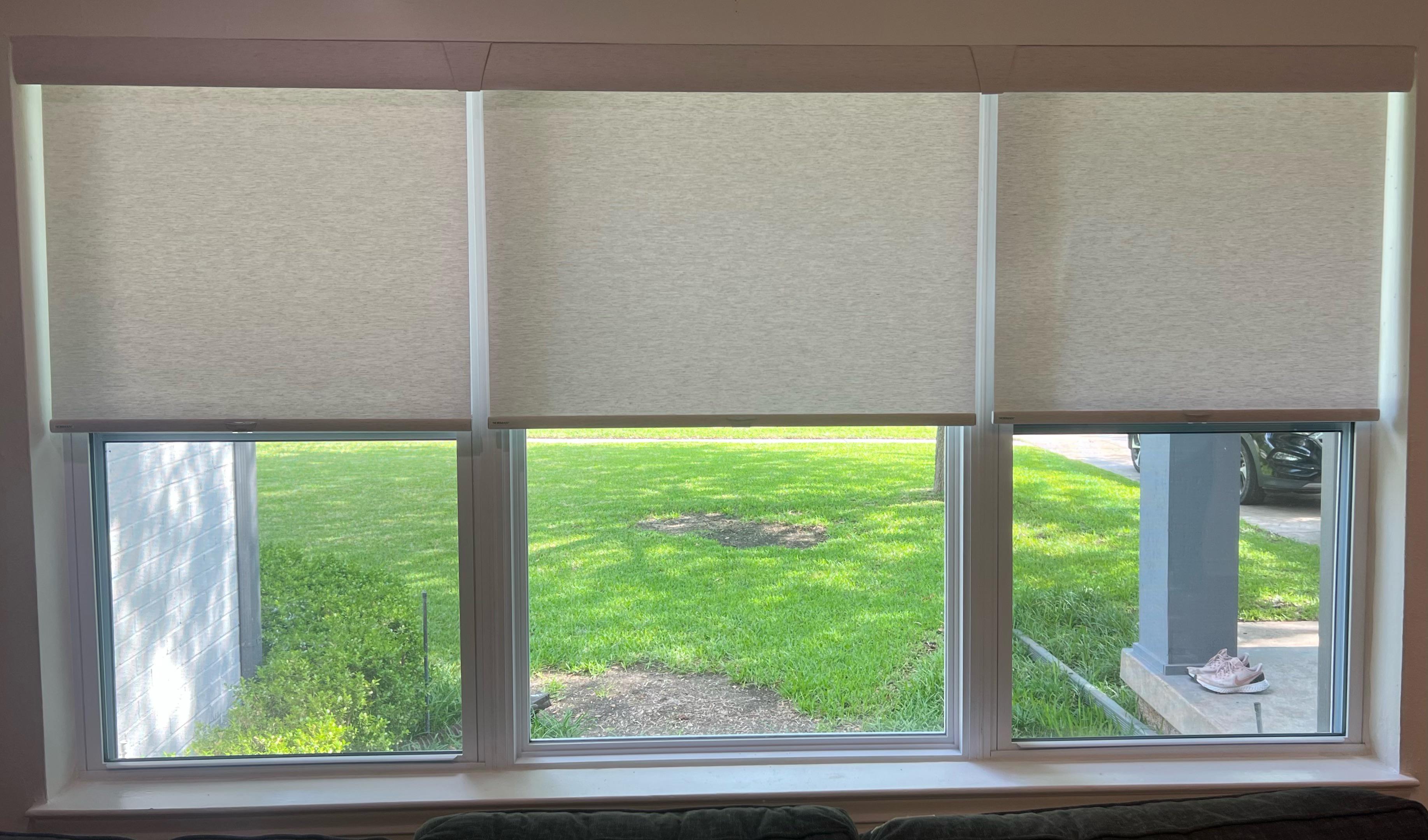 Cordless roller shades on three side by side windows with one valance is ideal for a clean, contemporary look. Our team at Budget Blinds of Rockwall, Terrell, and Greenville can help you select the best options for your unique window needs.