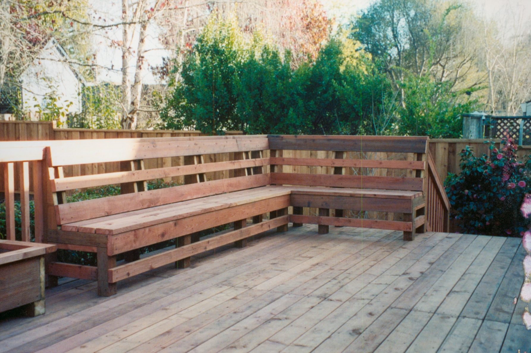 Built-in wood bench seating with matching fence surround, creating a comfortable outdoor living area.