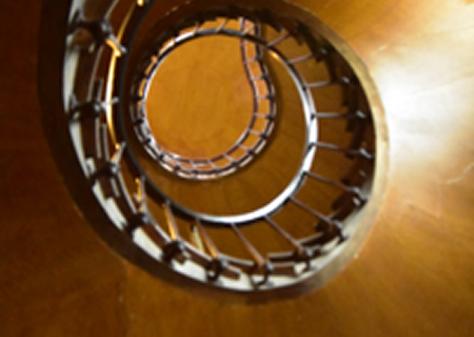 Vue de bas en haut d'un escalier en colimaçon.