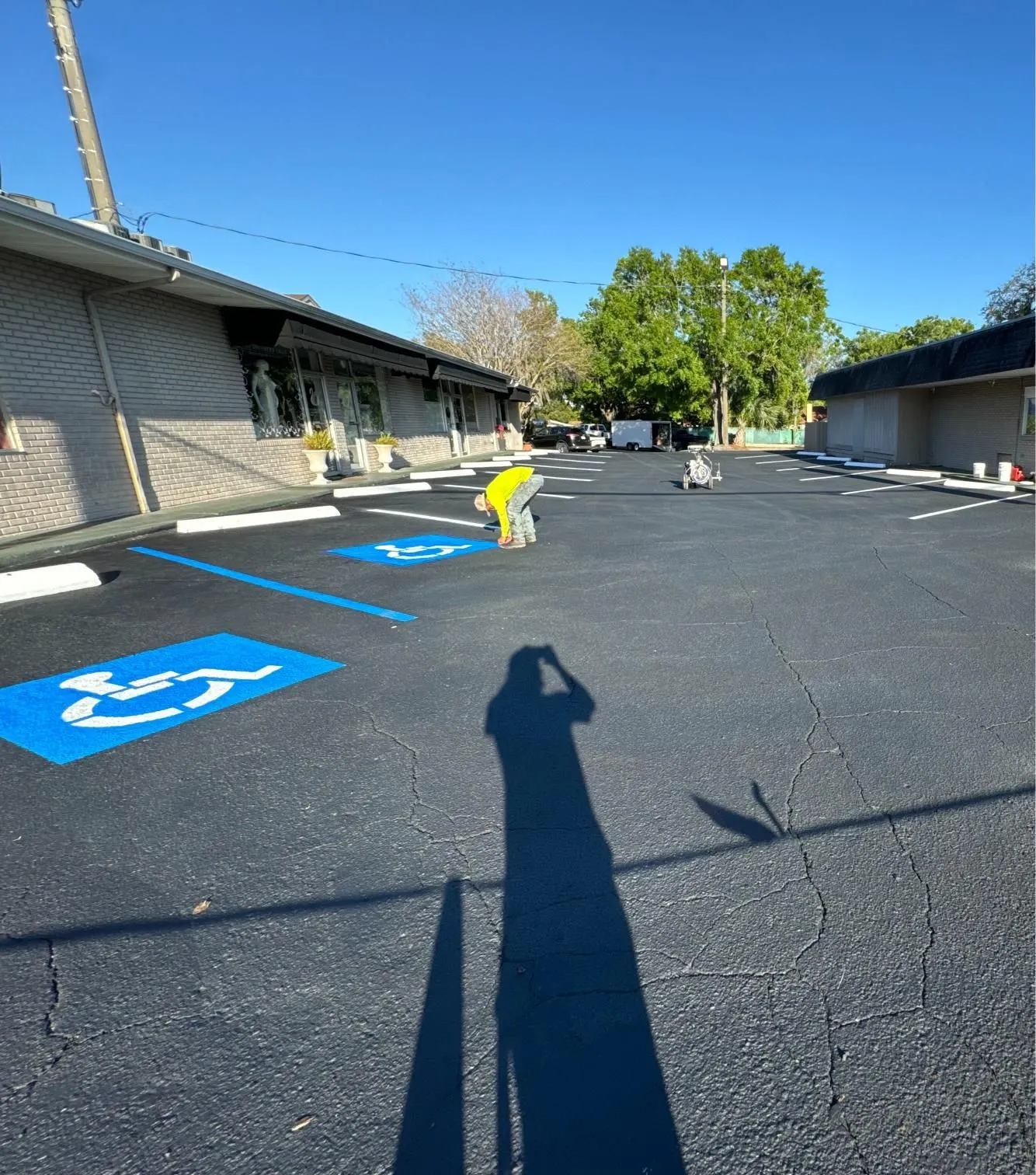 Accessible parking spaces receiving fresh blue ADA markings and compliance striping to improve accessibility and parking lot functionality.