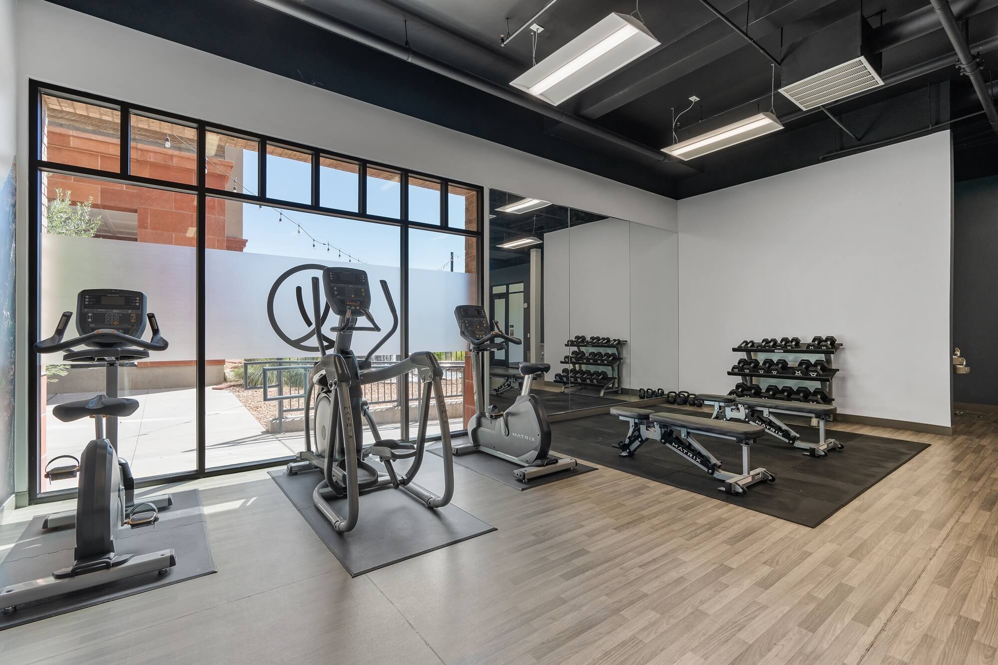 a gym with weights and other exercise equipment and a large window