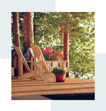 Muskoka chairs on a sunlit deck.