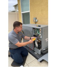 An Aced It! Cooling & Heating technician servicing an outdoor air conditioning unit at a residential property in Corona, CA. The technician is shown using advanced tools, demonstrating the company’s commitment to reliable and professional HVAC repair and maintenance. Highlighting local expertise, this photo emphasizes the trusted services provided to homeowners in the area.